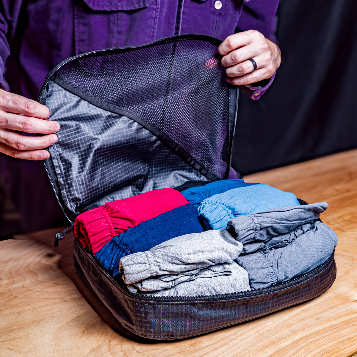 Backpacker puts a Bear Vault Bear Canister into a ULA CDT Backpack