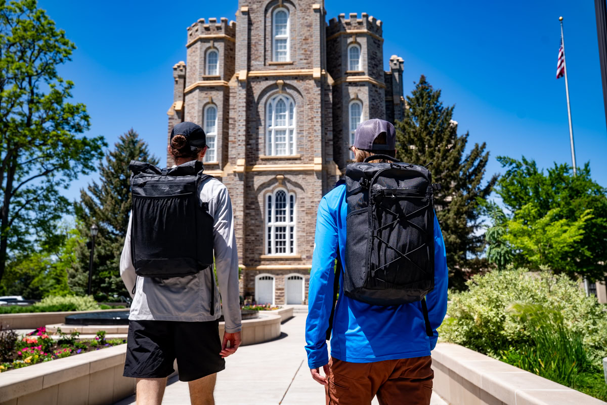 A woman in a coffee shop removes her laptop from the ULA Packrat