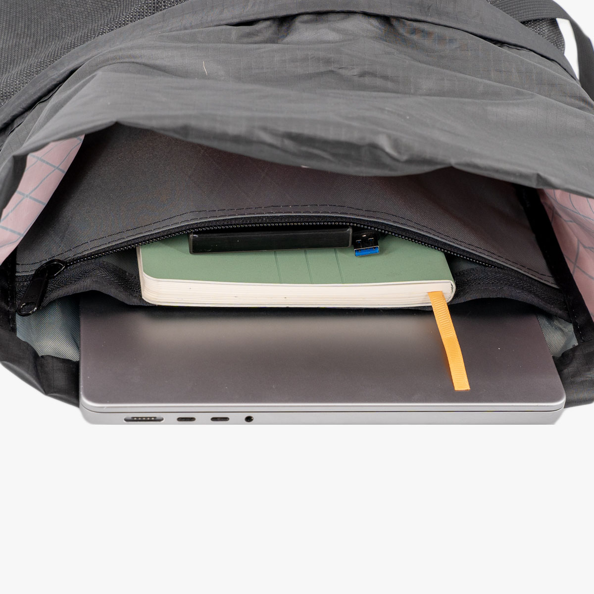 A laptop and notebook inside of a packrat
