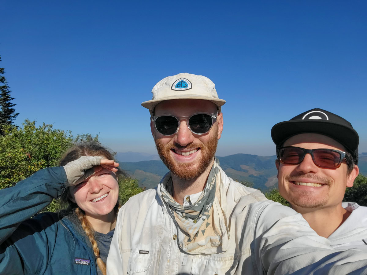 Two men and a woman smile into the camera