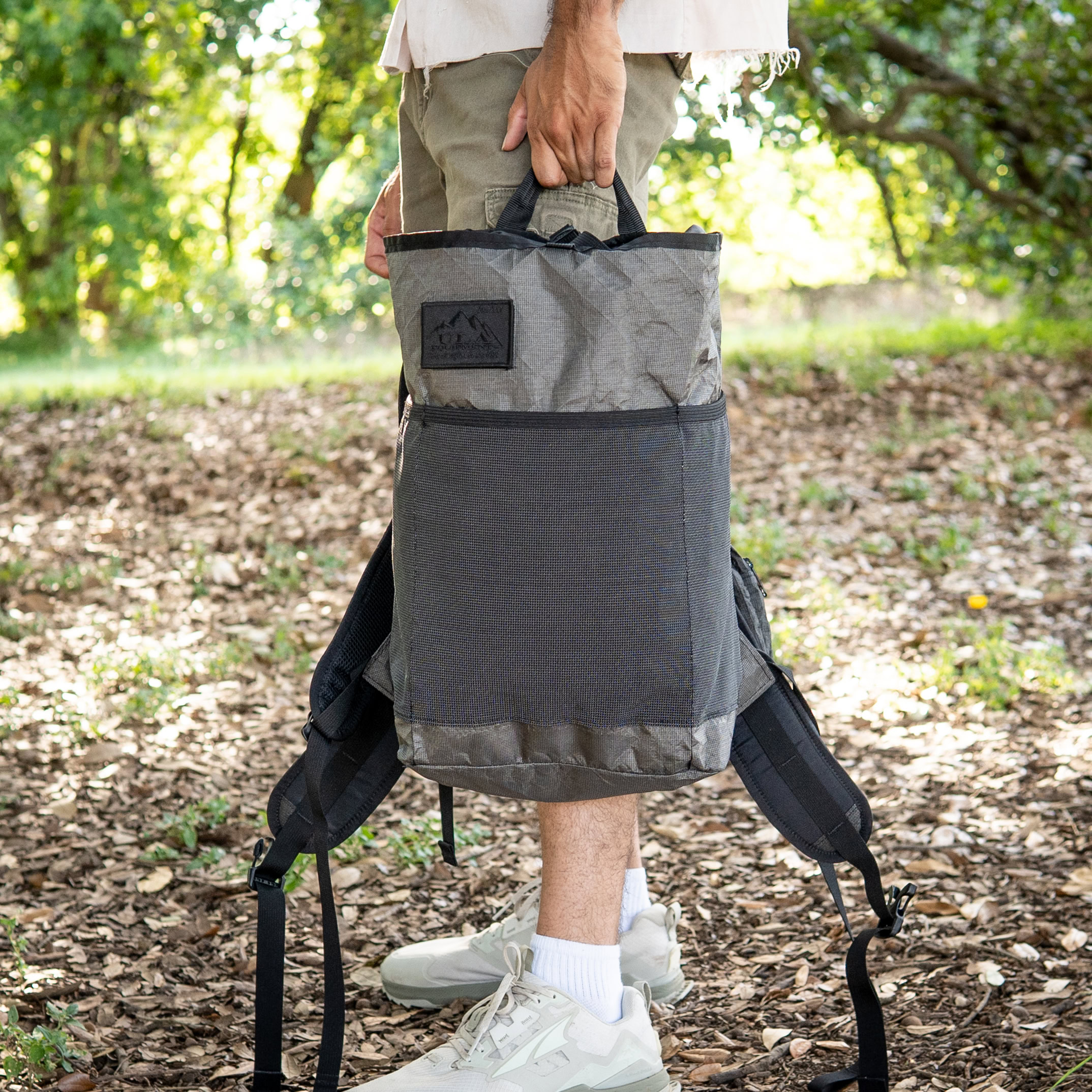 a man holds an ultra packrat by his side.