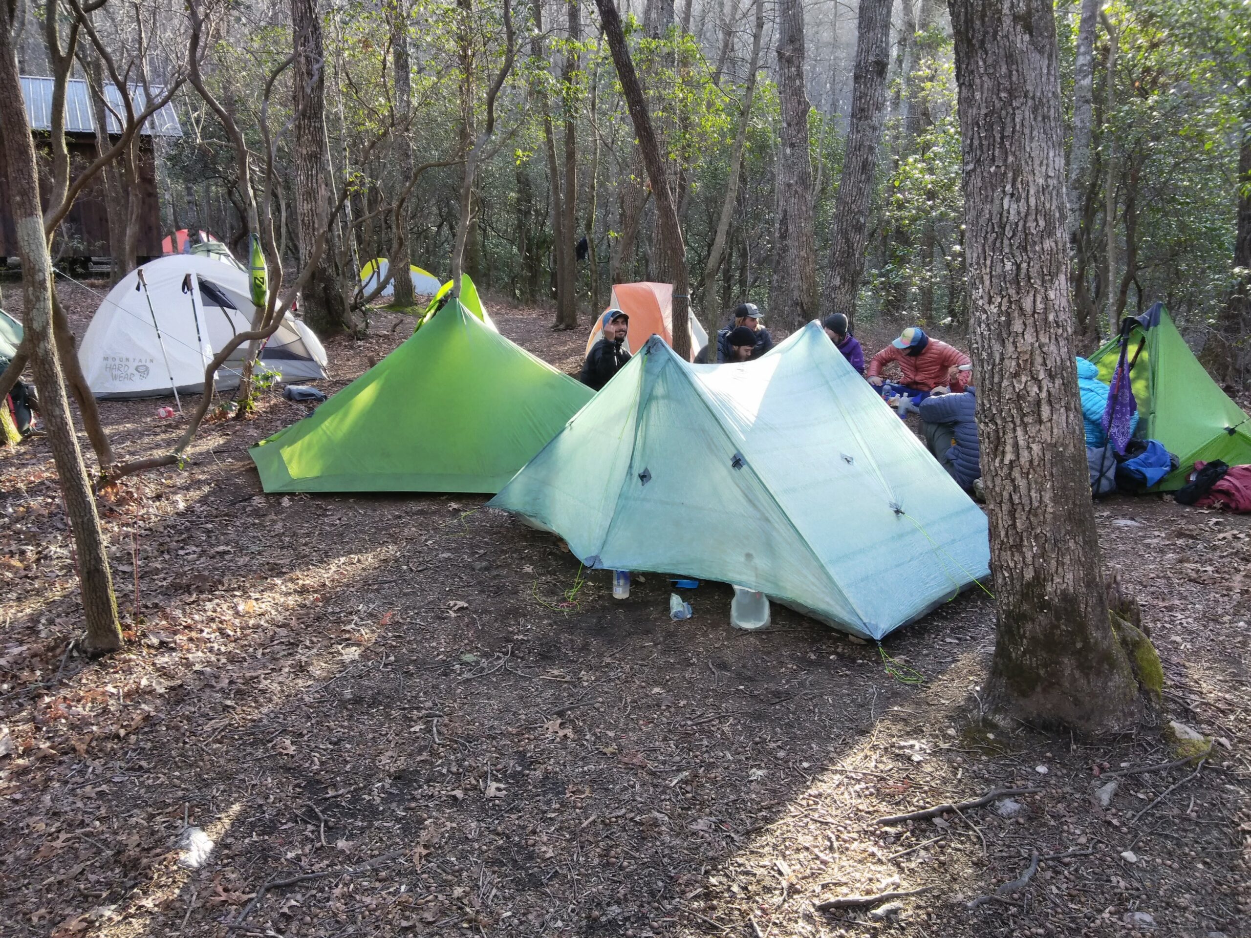 A group of hikers with tents near a shelter